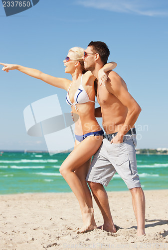 Image of happy couple in sunglasses on the beach