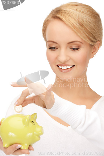 Image of lovely woman with piggy bank and money