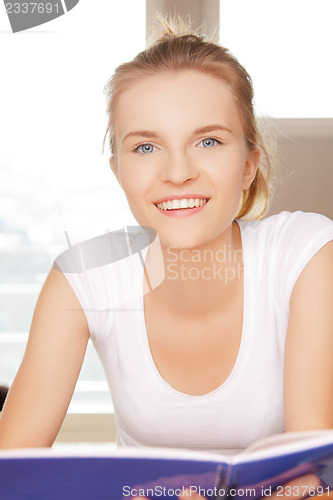 Image of happy and smiling teenage girl with big notepad