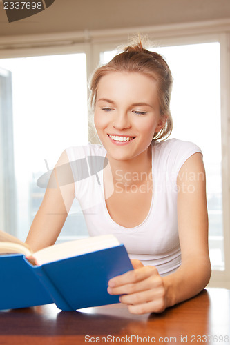 Image of happy and smiling teenage girl with book