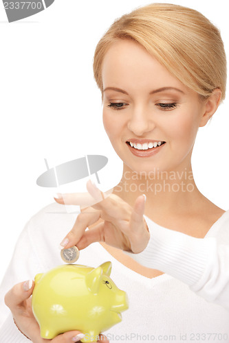 Image of lovely woman with piggy bank and money