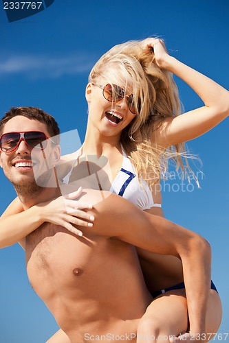 Image of happy couple in sunglasses on the beach