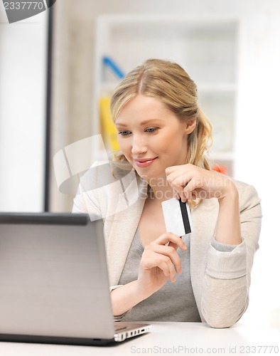 Image of happy woman with laptop computer and credit card