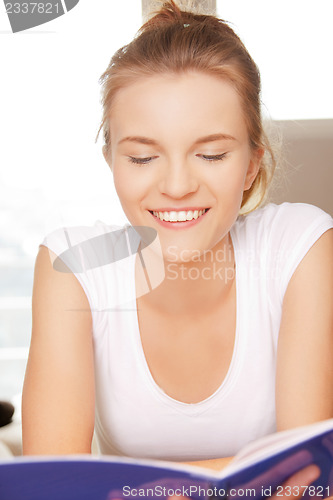 Image of happy and smiling teenage girl with big notepad