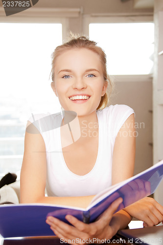 Image of happy and smiling teenage girl with big notepad