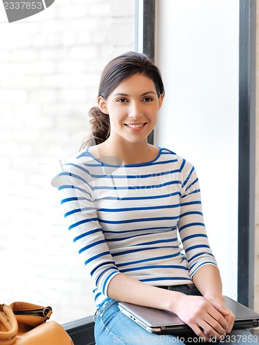 Image of happy and smiling teenage girl with laptop