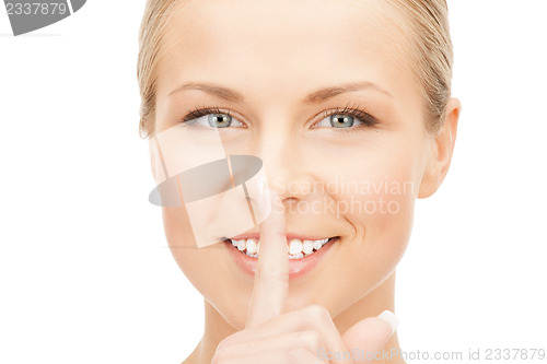 Image of happy woman with finger on lips