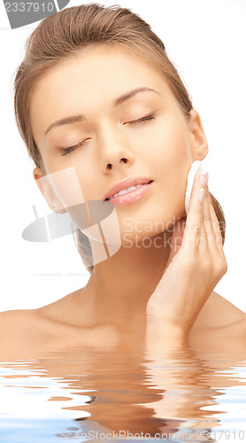 Image of beautiful woman with cotton pad in water
