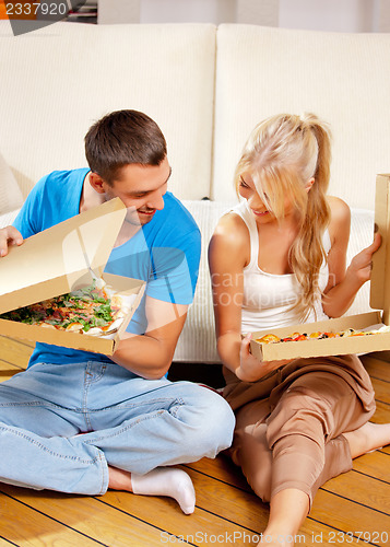 Image of romantic couple eating pizza at home