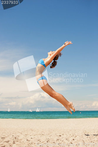 Image of happy jumping woman on the beach