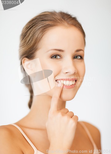 Image of beautiful woman pointing to teeth