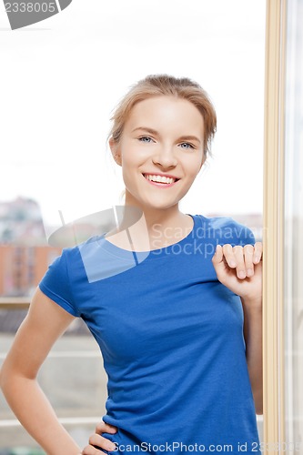 Image of happy teenage girl at the window
