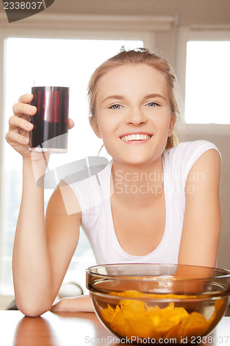Image of smiling teenage girl with chips and coke