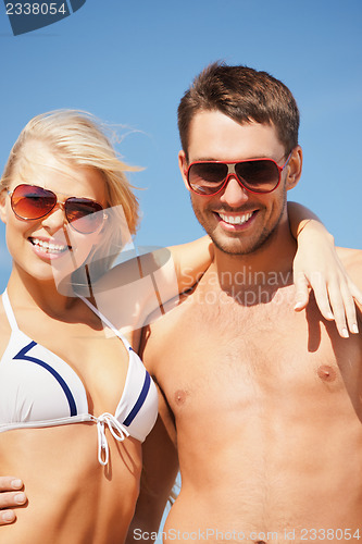 Image of happy couple in sunglasses on the beach