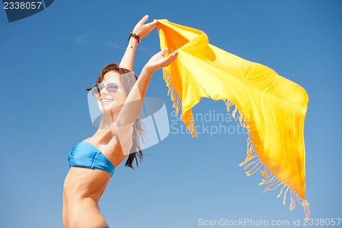 Image of happy woman with yellow sarong on the beach