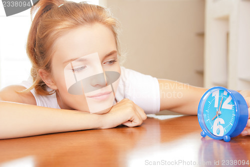 Image of happy and smiling teenage girl with clock