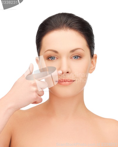 Image of beautiful woman pointing to nose