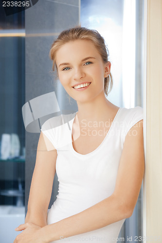 Image of happy and smiling teenage girl in a bathroom