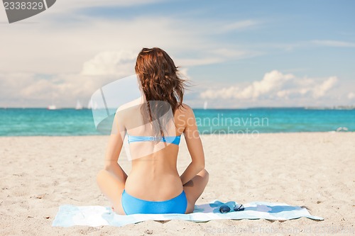 Image of woman sitting on a towel