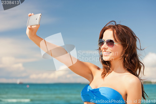 Image of happy woman with phone on the beach
