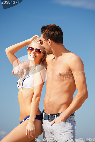 Image of happy couple in sunglasses on the beach