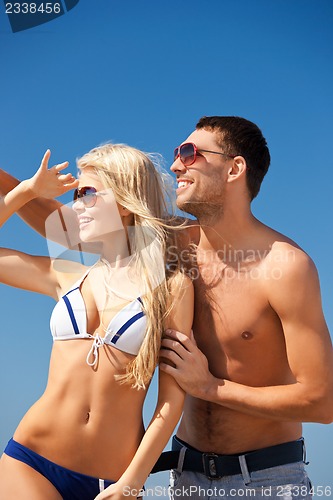 Image of happy couple in sunglasses on the beach