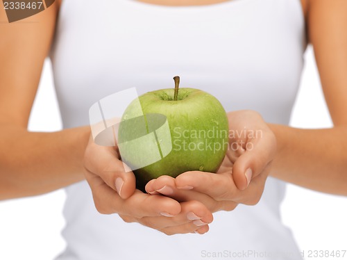 Image of female hands with green apple