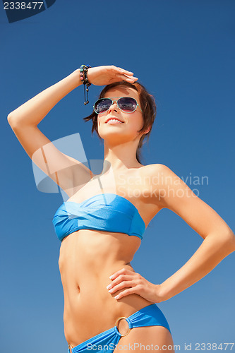 Image of happy woman in sunglasses on the beach