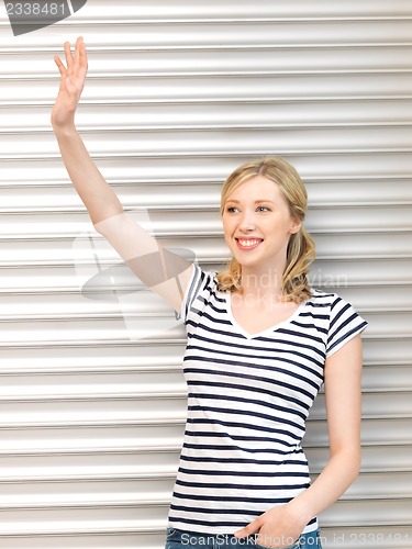 Image of happy teenage girl waving a greeting