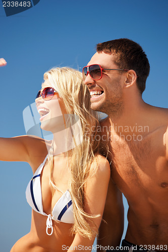 Image of happy couple in sunglasses on the beach