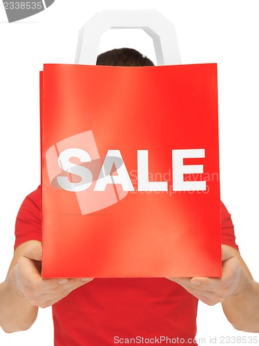 Image of man's hands holding shopping bag