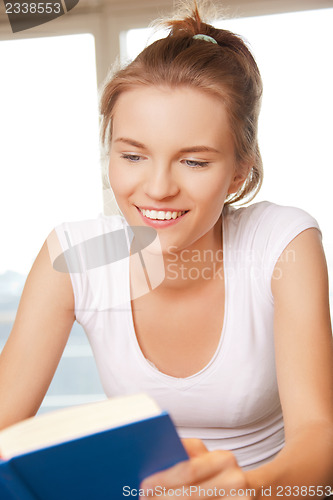 Image of happy and smiling teenage girl with book