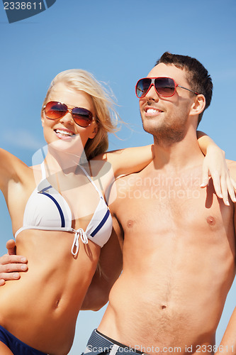 Image of happy couple in sunglasses on the beach