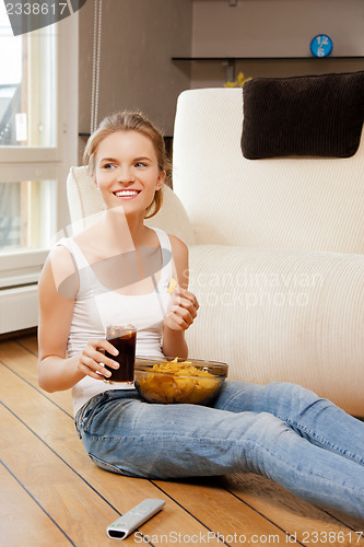Image of smiling teenage girl with remote control