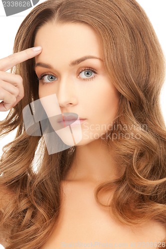 Image of beautiful woman pointing to forehead