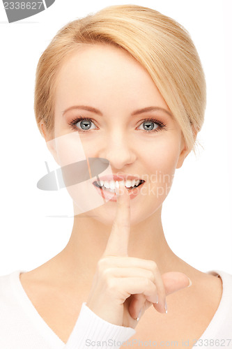 Image of happy woman with finger on lips