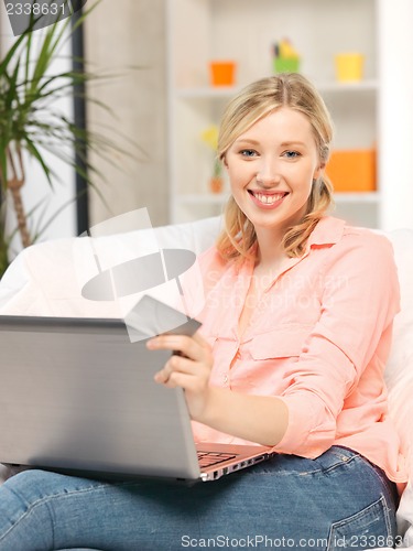 Image of happy woman with laptop computer and credit card