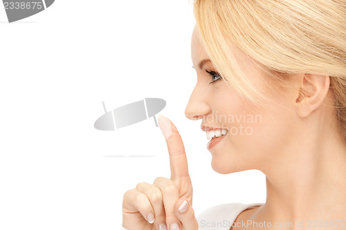 Image of happy woman with finger on lips