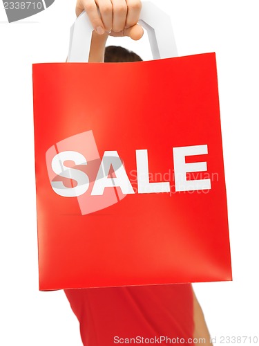 Image of man's hands holding shopping bag