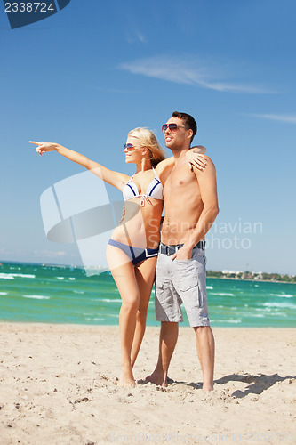 Image of happy couple in sunglasses on the beach