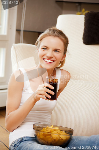 Image of smiling teenage girl with chips and coke