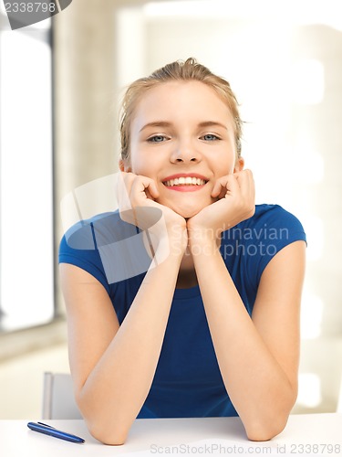 Image of happy teenage girl with pen and paper