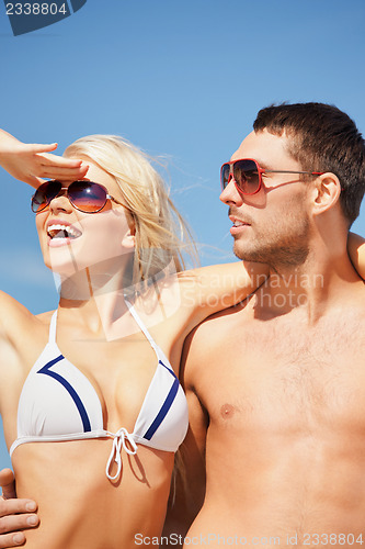 Image of happy couple in sunglasses on the beach