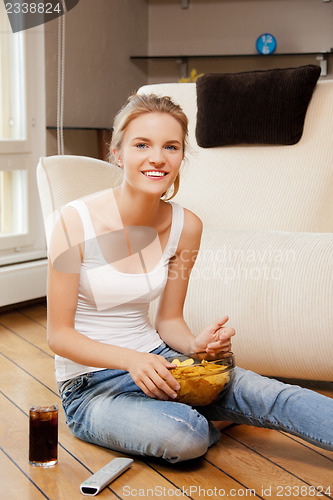 Image of smiling teenage girl with remote control