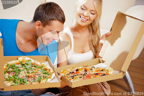 Image of romantic couple eating pizza at home