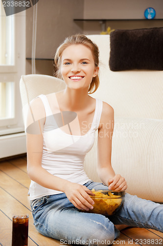 Image of smiling teenage girl with chips and coke