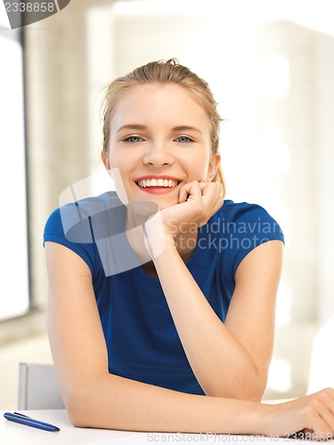 Image of happy teenage girl with pen and paper