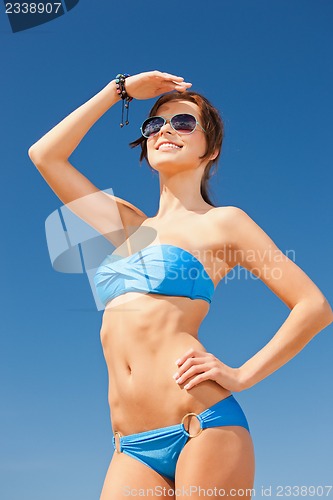 Image of happy woman in sunglasses on the beach