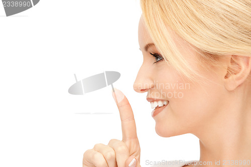 Image of happy woman with finger on lips