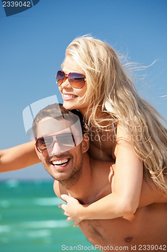 Image of happy couple in sunglasses on the beach